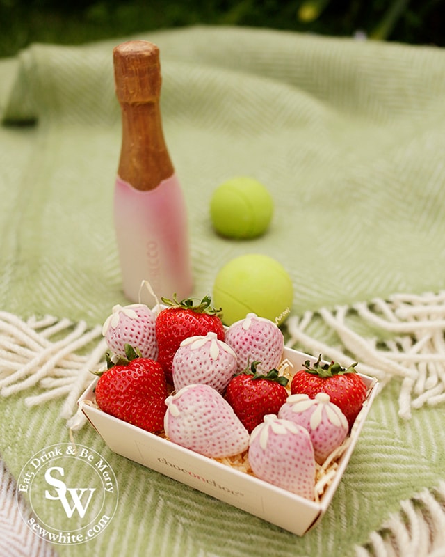 Chocolate tennis set from Choc on Choc. Chocolate strawberries, chocolate pink and gold shimmer prosecco bottle and chocolate tennis balls.